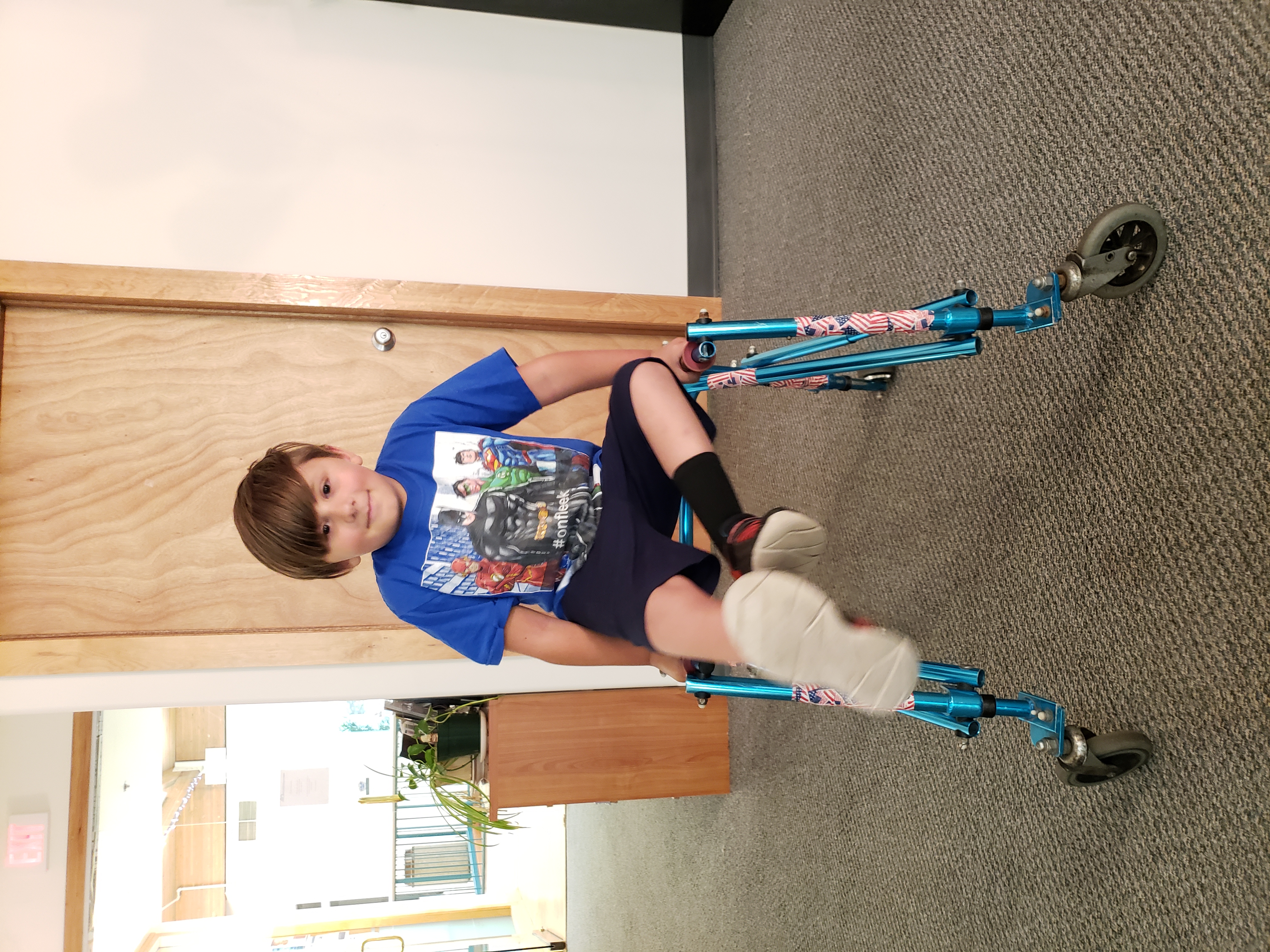 a young boy kicking his legs up in the air while holding onto a walker